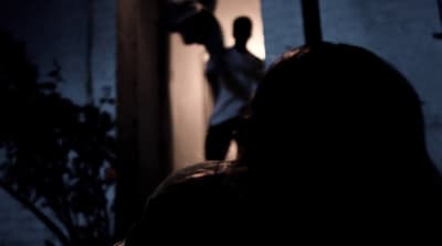 a person standing in front of a door in the dark