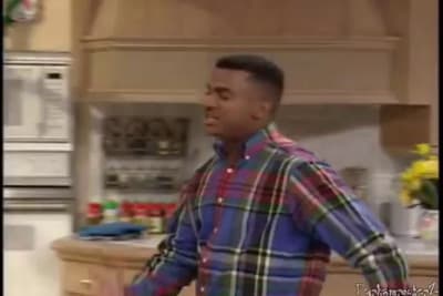 a man in a plaid shirt standing in a kitchen