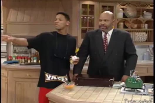 a couple of men standing next to each other in a kitchen