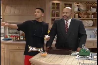 a couple of men standing next to each other in a kitchen
