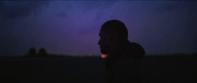 a man standing in a field at night