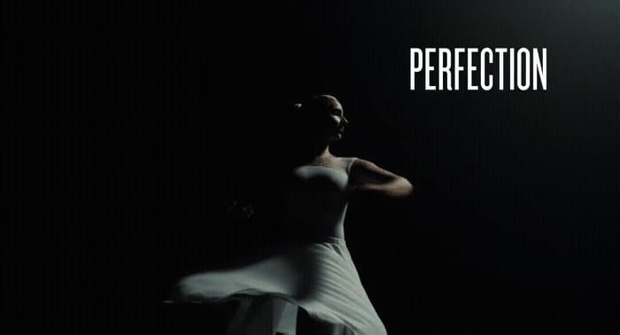 a woman in a white dress standing in the dark