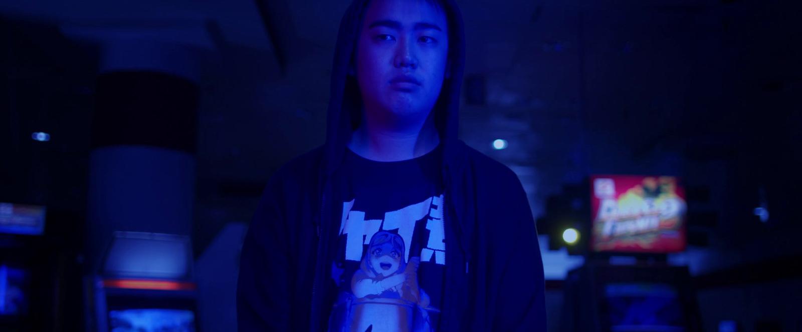 a man standing in a dark room holding a remote