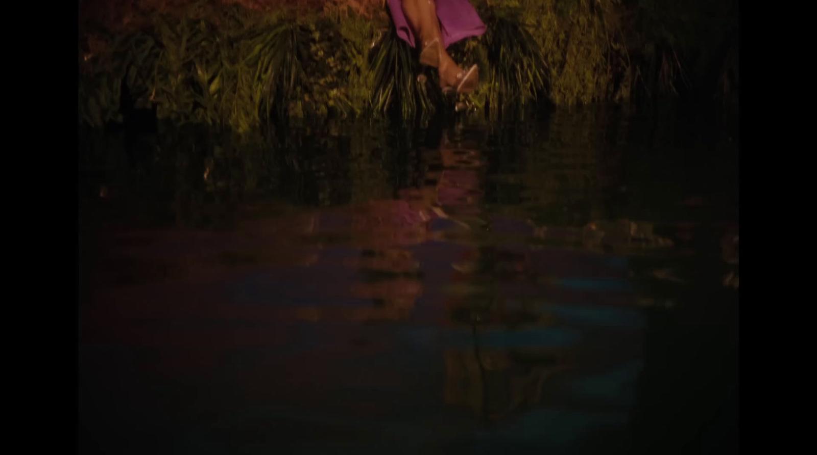a woman in a purple dress is standing in the water