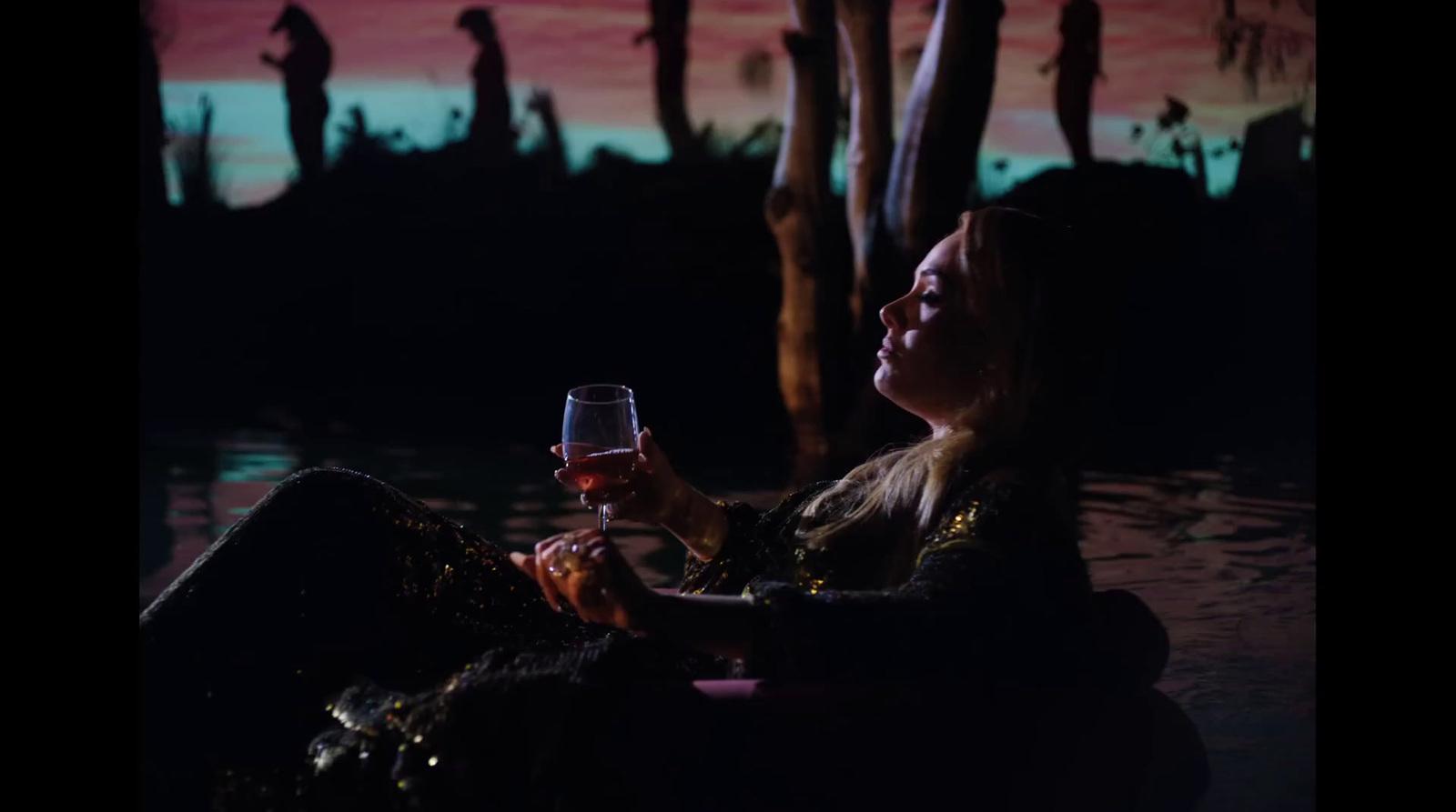 a woman holding a glass of wine in her hand