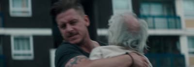 a man holding a woman in front of a building