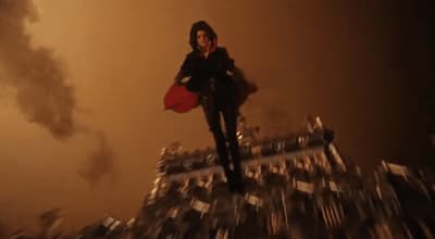 a woman standing on top of a pile of silver objects