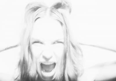 a black and white photo of a woman with her mouth open