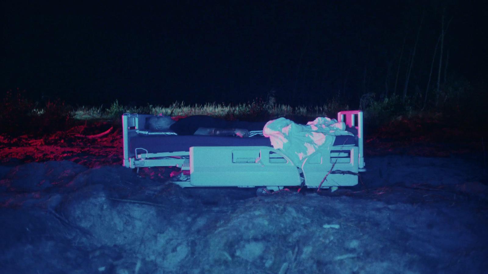 a person laying on a bed in the dark