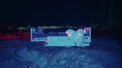 a person laying on a bed in the dark