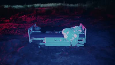 a person laying in a bed in a field