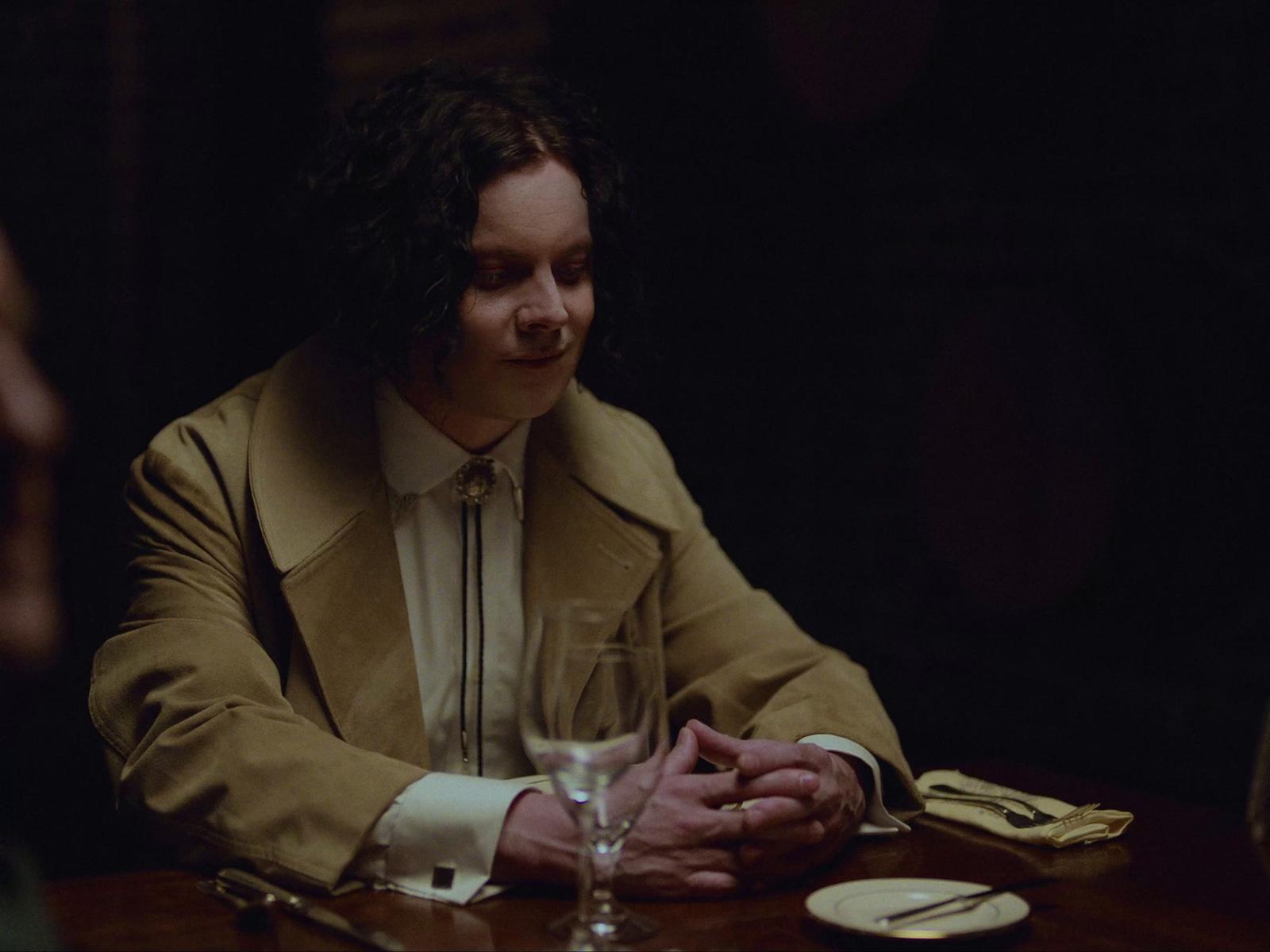 a man sitting at a table with a wine glass