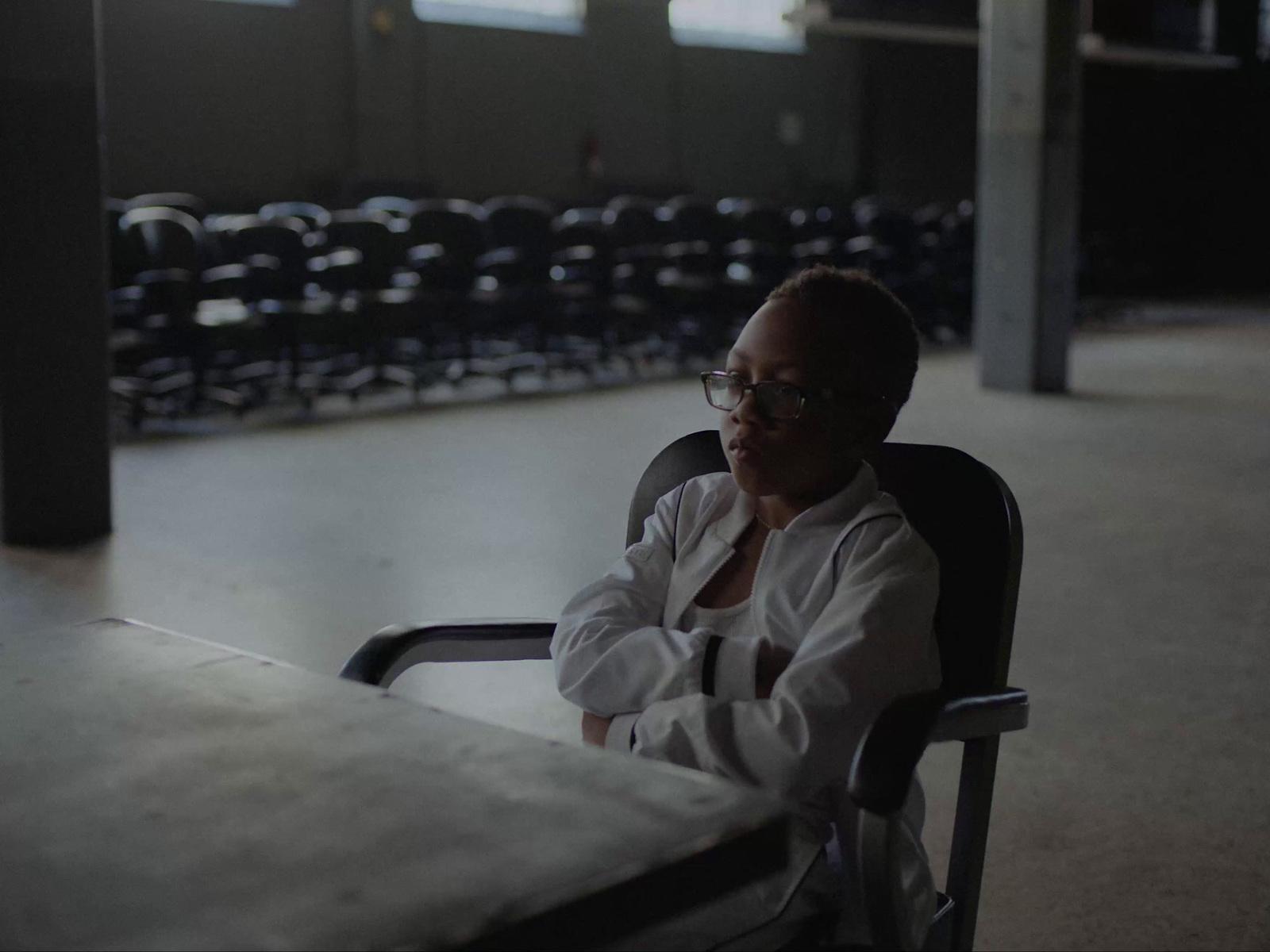 a woman sitting in a chair in an empty room