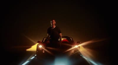a man standing in front of a car in the dark