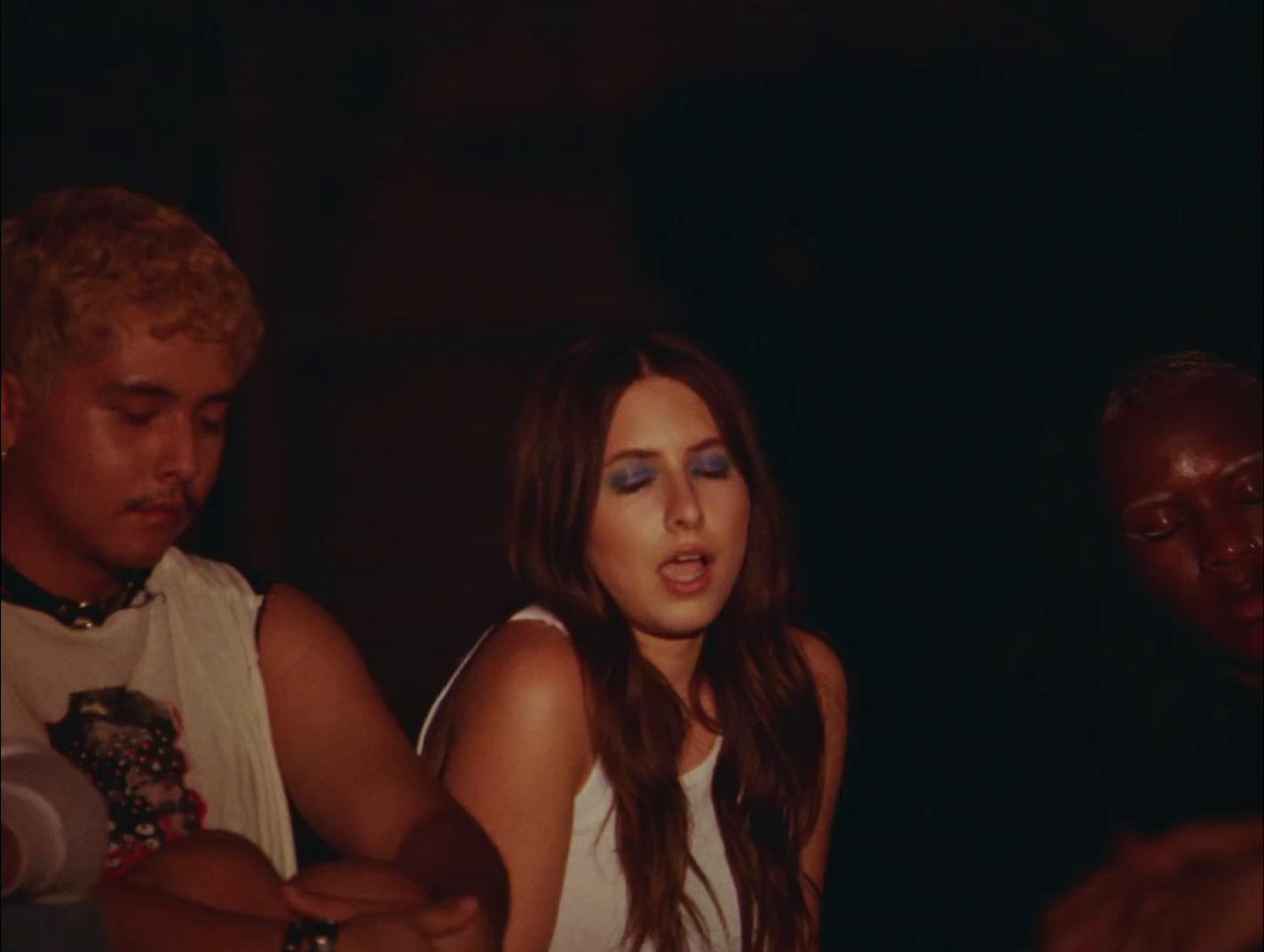a woman in a white tank top standing next to a man