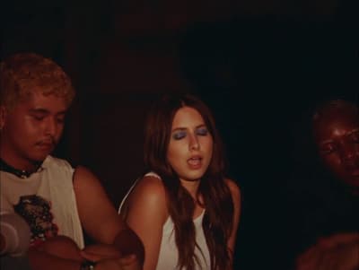 a woman in a white tank top standing next to a man