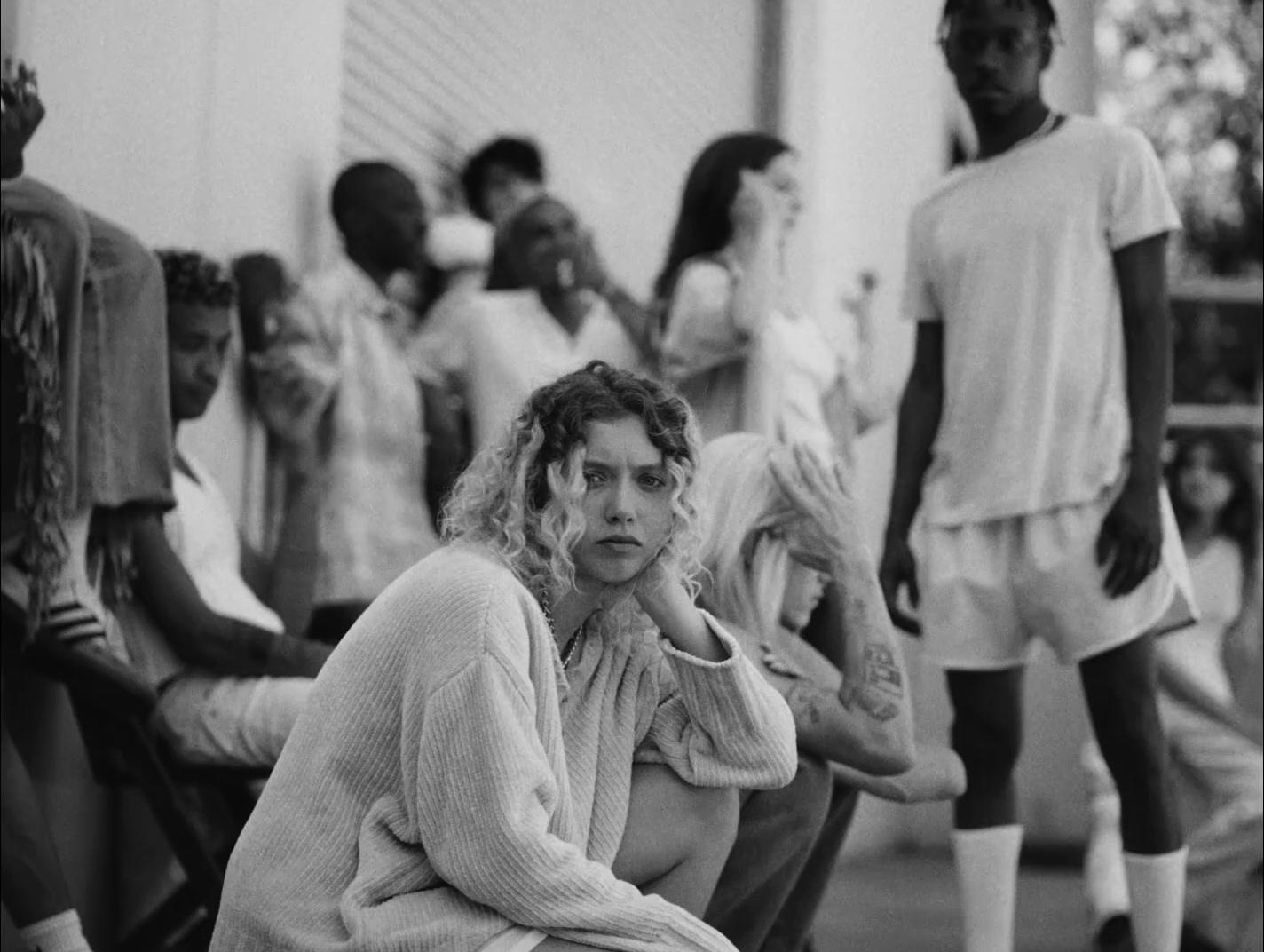 a woman sitting on a chair in front of a group of people