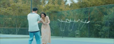 a man and a woman standing on a tennis court