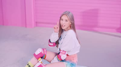 a girl sitting on the ground with her legs crossed