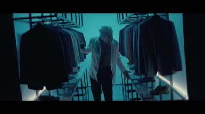 a woman is walking through a clothing store