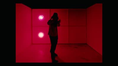 a woman standing in a room with red lights