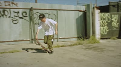 a man riding a skateboard down a sidewalk