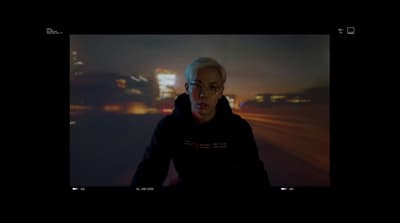 a man in a black hoodie is looking at the camera