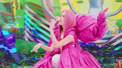a woman in a pink dress standing on a stage