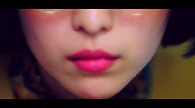 a close up of a woman's face with pink lipstick