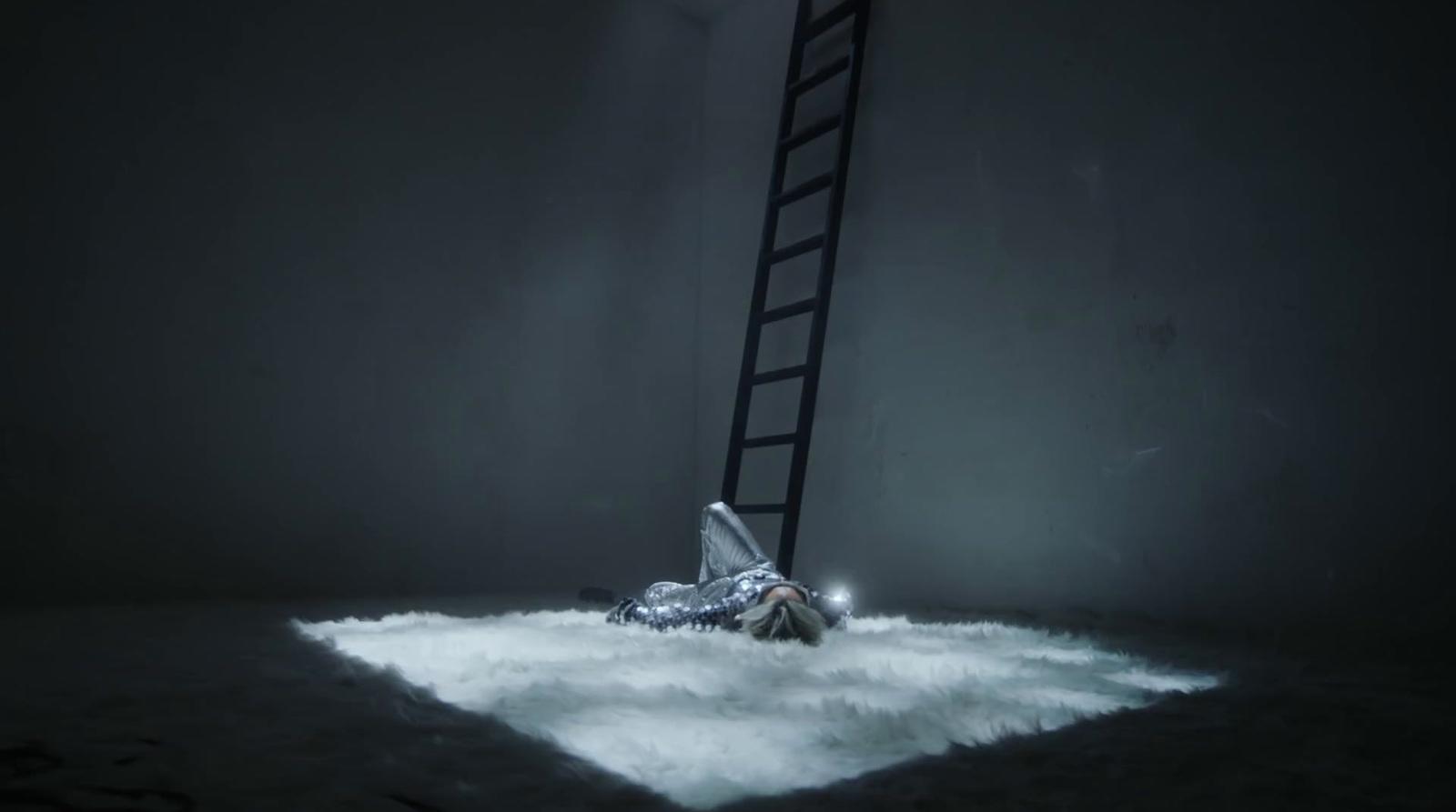 a man laying on the ground under a ladder