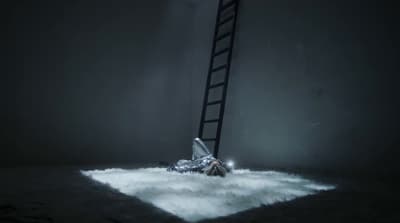 a man laying on the ground under a ladder