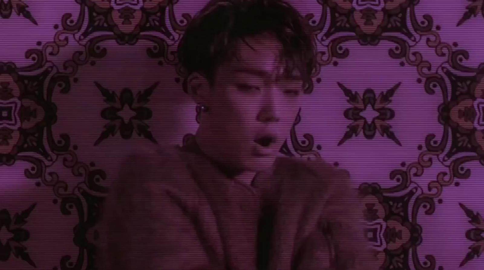 a man standing in front of a purple wall