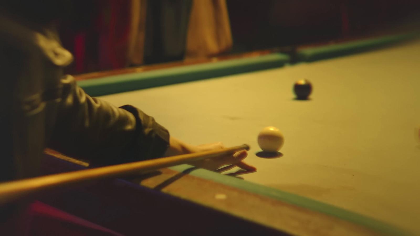 a pool table with a pool ball and cues