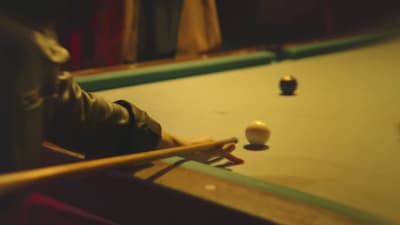 a pool table with a pool ball and cues