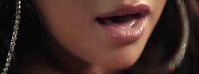 a close up of a woman's tongue with a chain around her neck