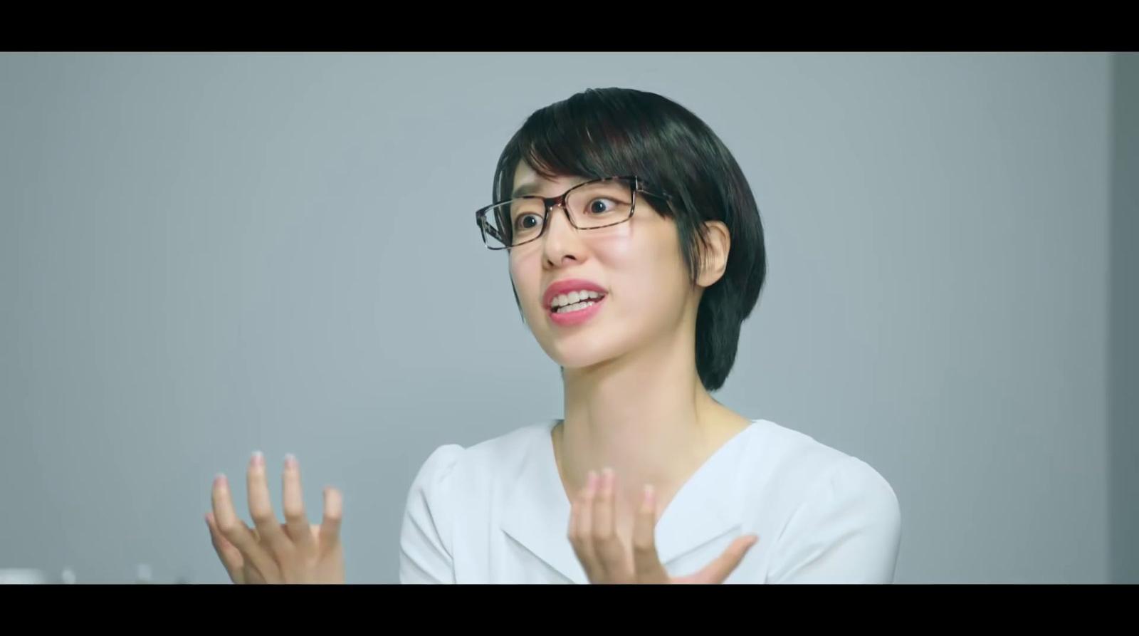 a woman wearing glasses and a white shirt