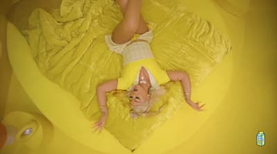 a woman laying on top of a yellow bed
