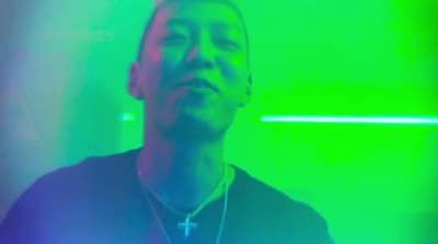 a man standing in front of a green and blue light