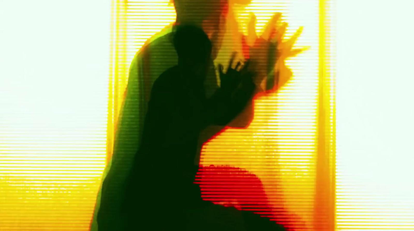 a silhouette of a person holding their hand up