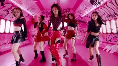 a group of young women dancing in a pink room