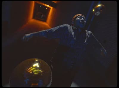 a man standing in front of a disco ball