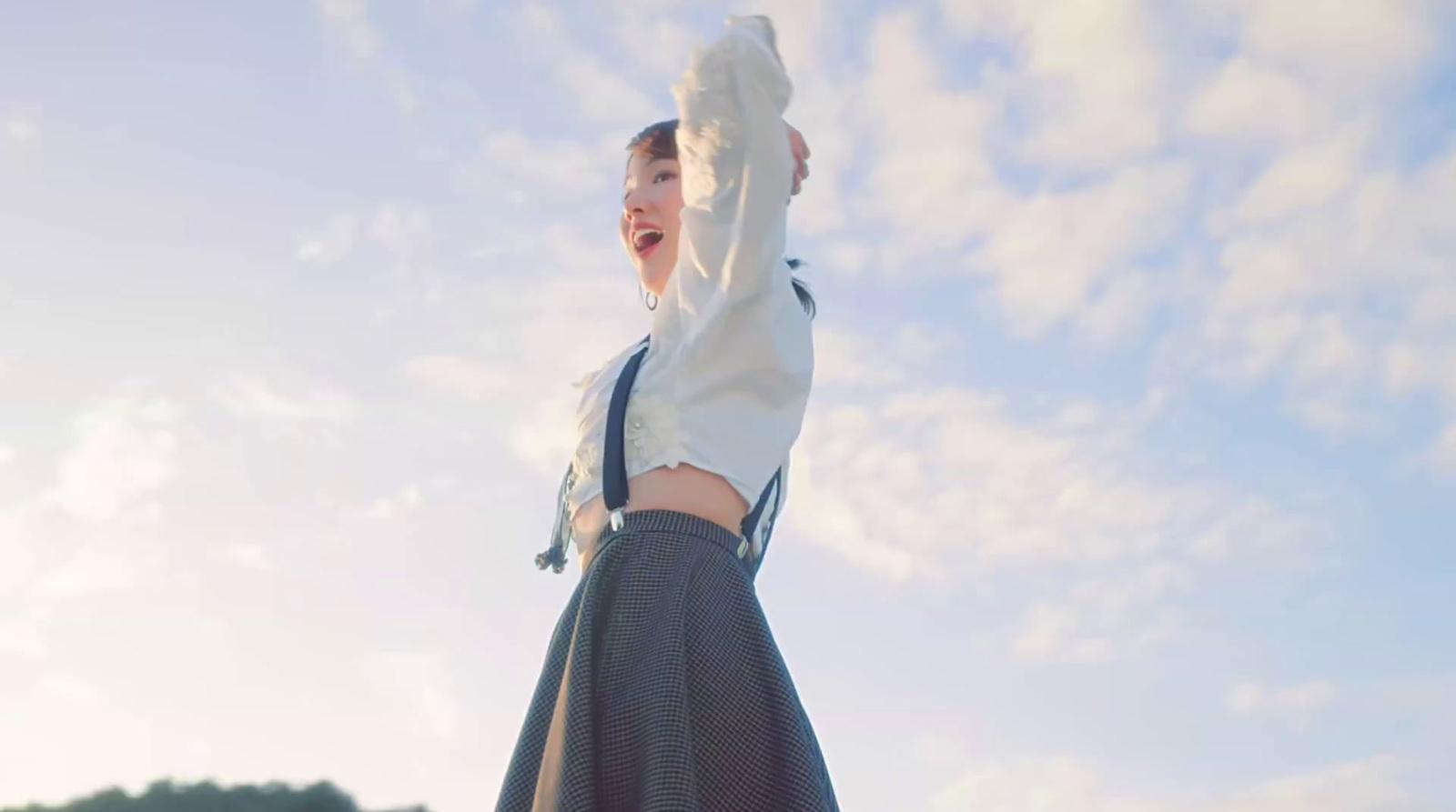 a woman in a skirt is holding a frisbee