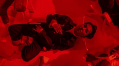 a man standing in a room with a red light