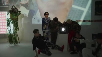 a group of people sitting on the floor in front of a projector screen