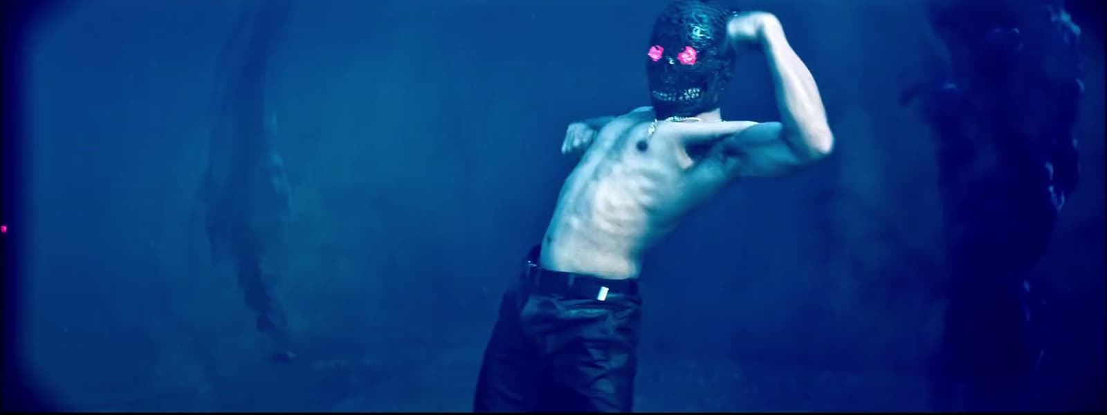 a shirtless man with a mask on holding a baseball bat