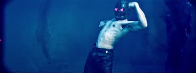 a shirtless man with a mask on holding a baseball bat