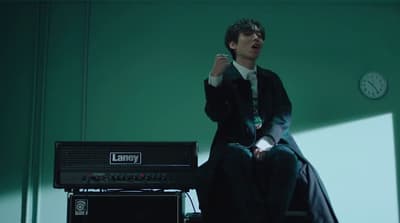 a man sitting on top of a chair next to a amp