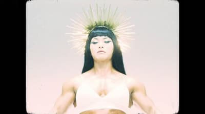 a woman in a white top with a spiked head