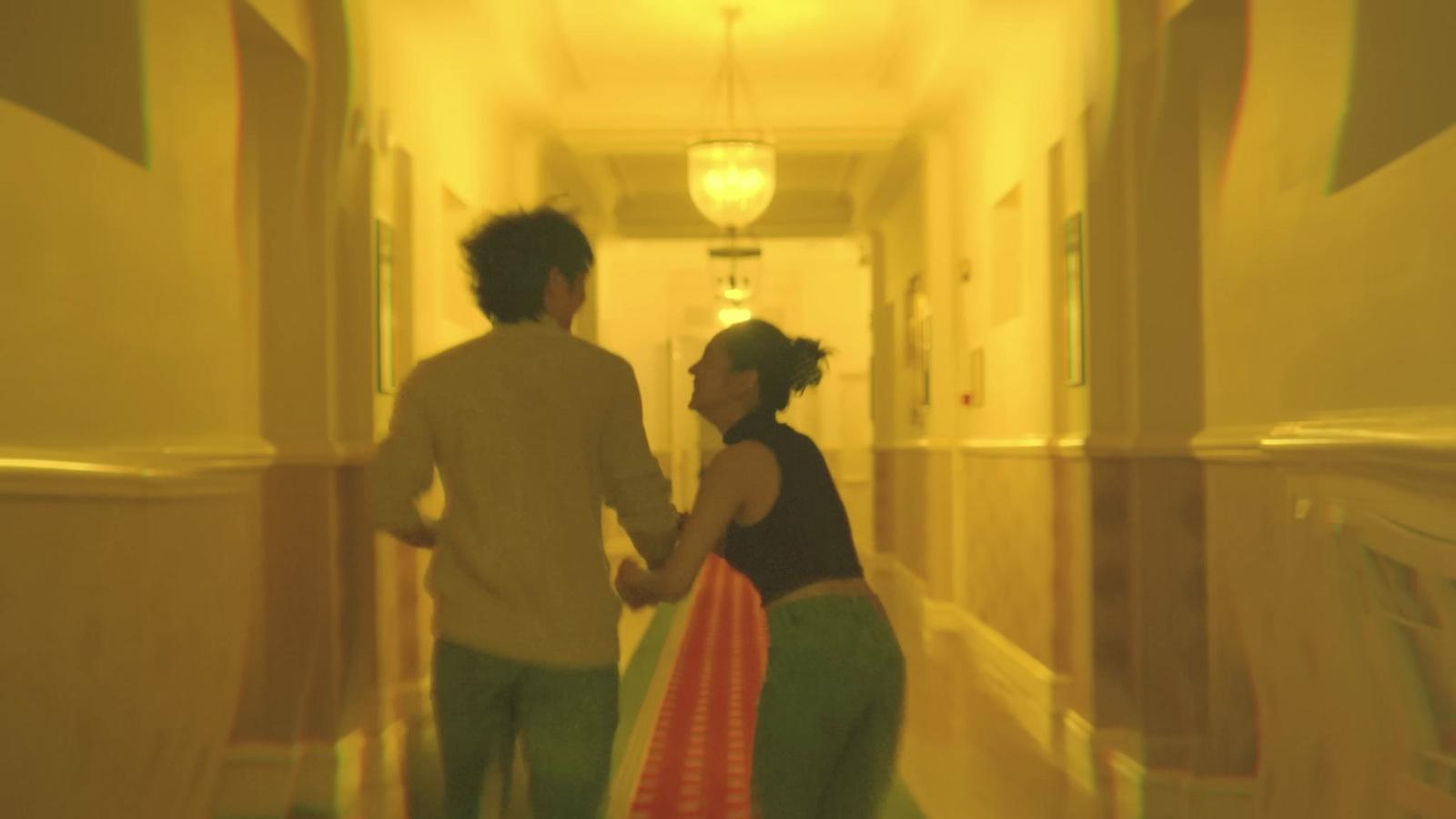 a man and a woman walking down a hallway