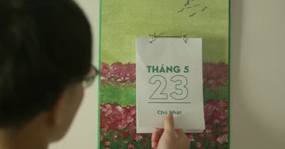 a person holding a sign that reads thang 5 23